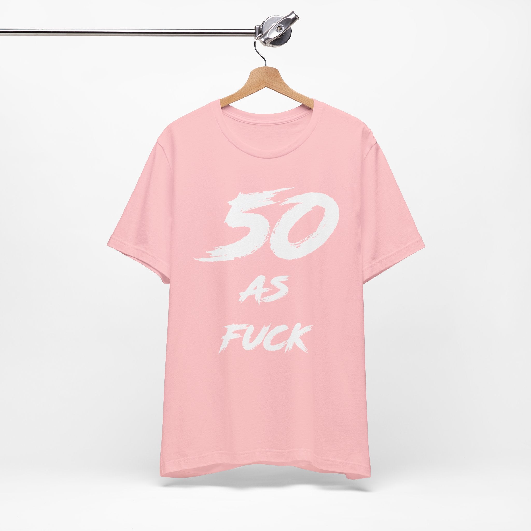 Pink birthday t-shirt on a hanger with the white 50 AS FUCK brush print