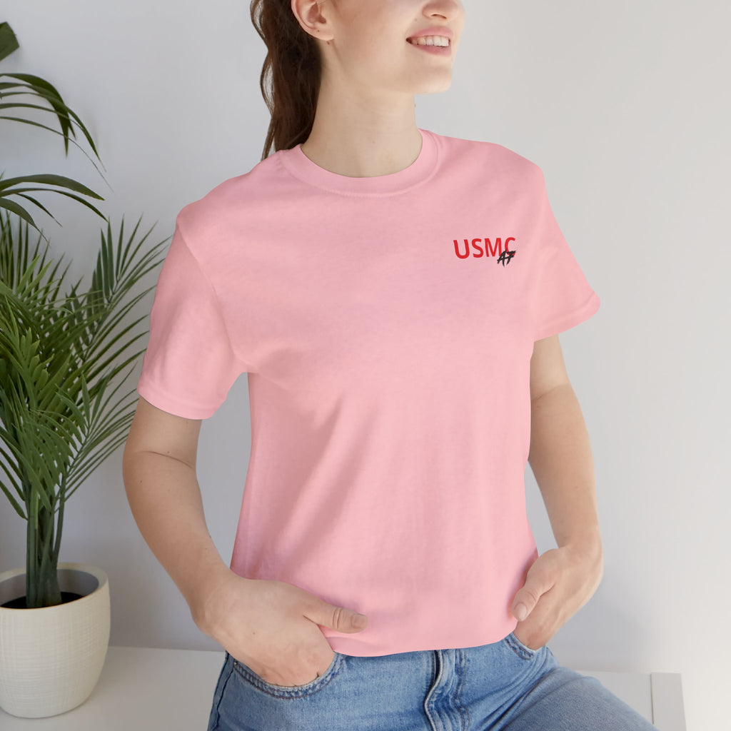 Woman wearing the Marine Corps veteran T-shirt in Pink beside a potted plant