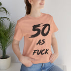 Woman by a houseplant in the Heather Peach tee, black 50 AS FUCK print