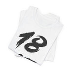Folded white birthday tees stacked, the black 18 showing on the top fold