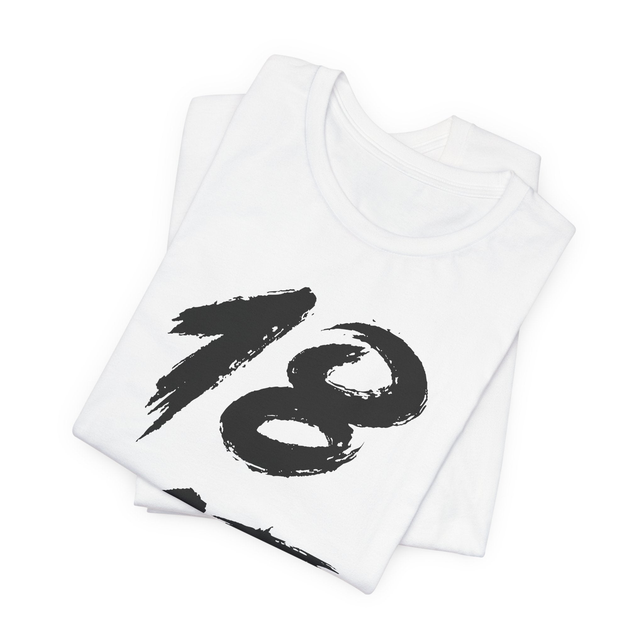 Folded white birthday tees stacked, the black 18 showing on the top fold