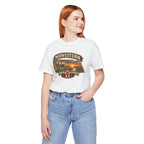 Woman wearing the white Nebraska tee with jeans, front print of the Nebraska sunset badge