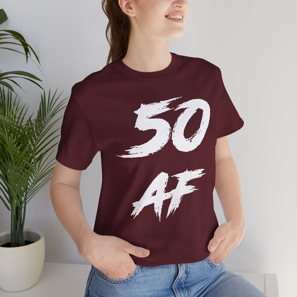 Woman beside a houseplant wearing the maroon 50 AF birthday t-shirt