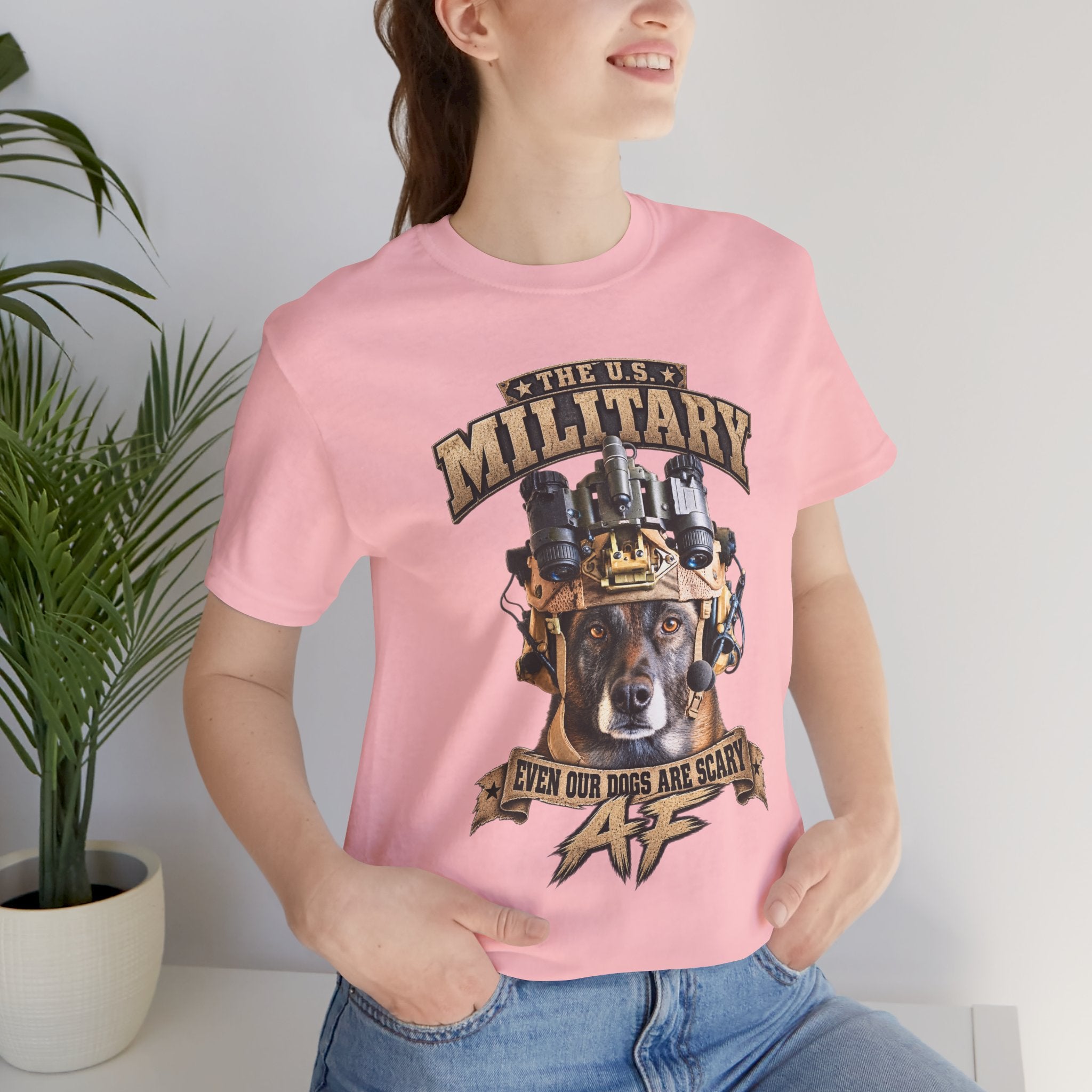 Woman wearing the Military K-9 T-shirt in Pink beside a potted plant
