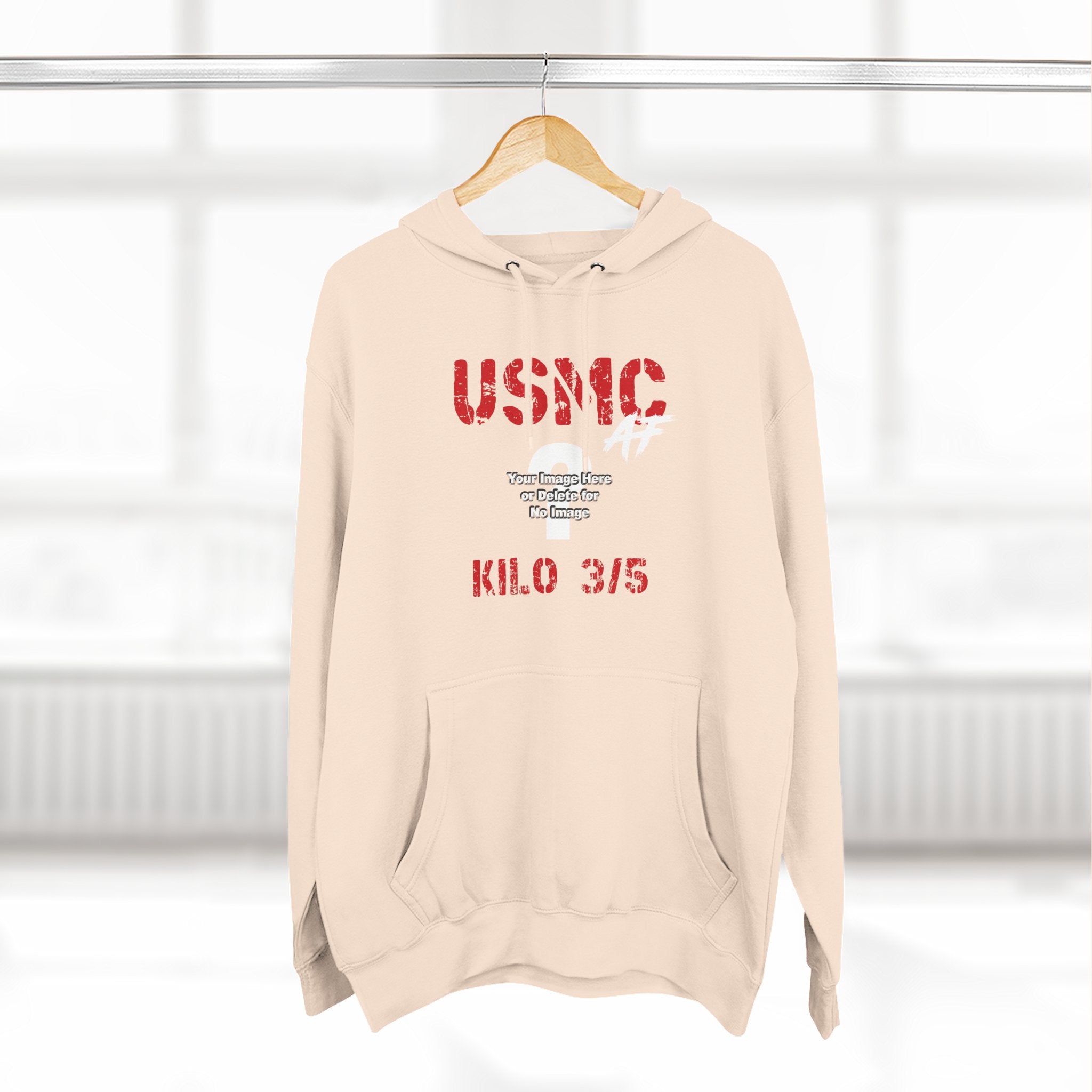 Personalized USMC Marine Corps AF hoodie in Sandshell on a wooden hanger in a bright room