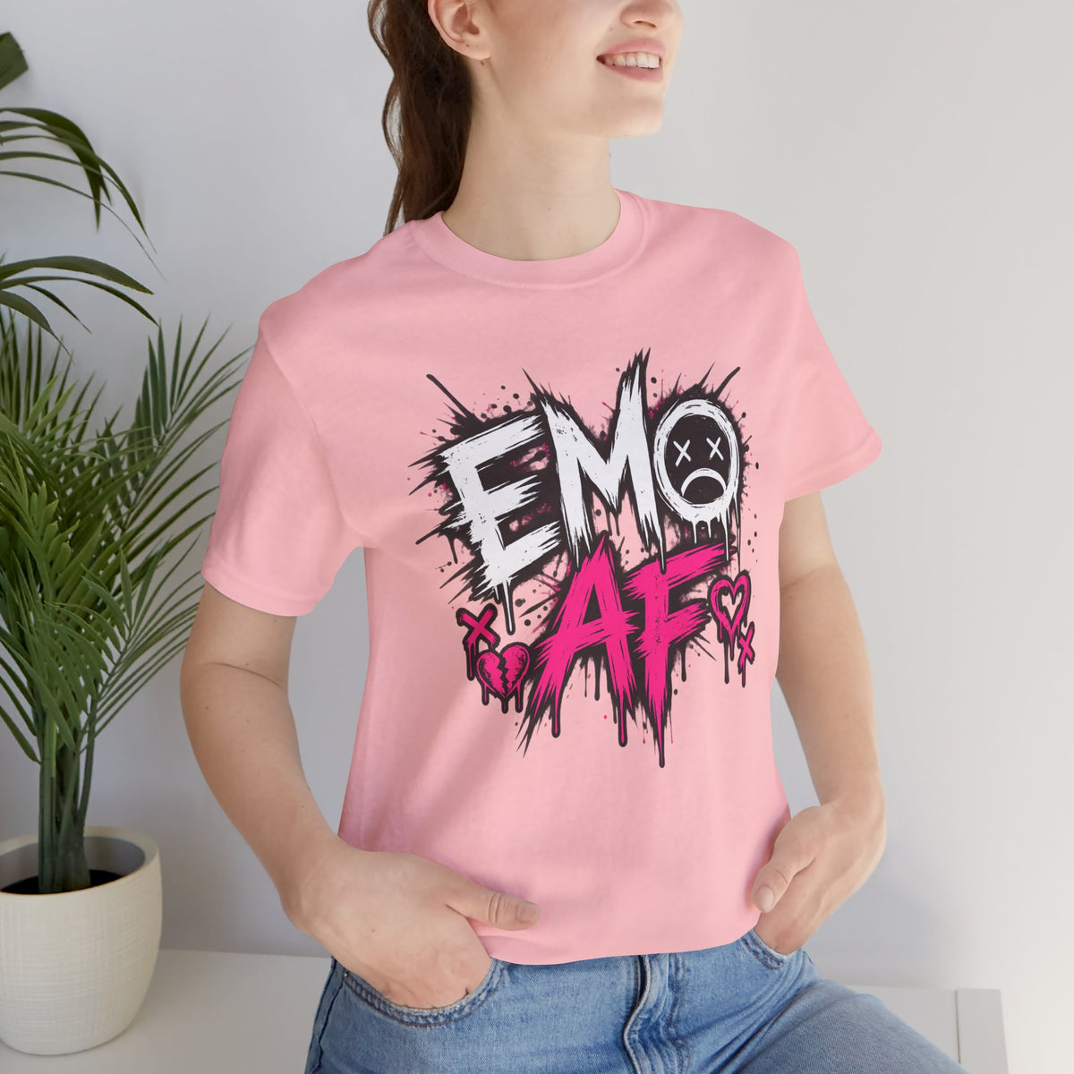Woman wearing the Pink EMO AF T-Shirt beside a houseplant, front graphic centred