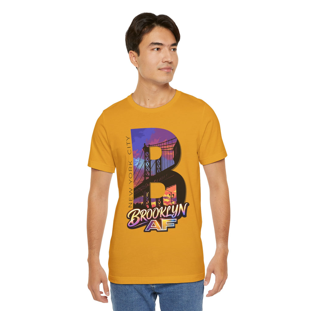 Mustard tee worn by a male model, front view, featuring the oversized "B" Brooklyn Bridge sunset skyline graphic.