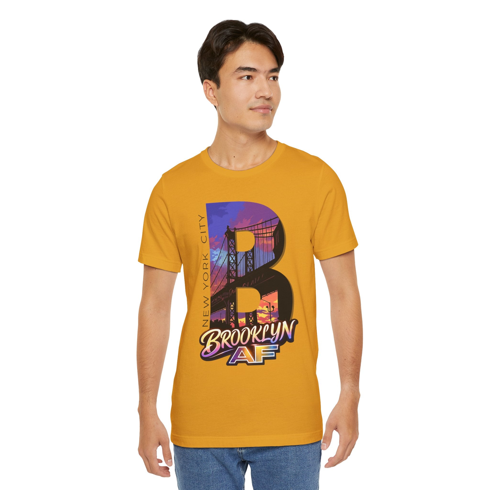 Mustard tee worn by a male model, front view, featuring the oversized "B" Brooklyn Bridge sunset skyline graphic.