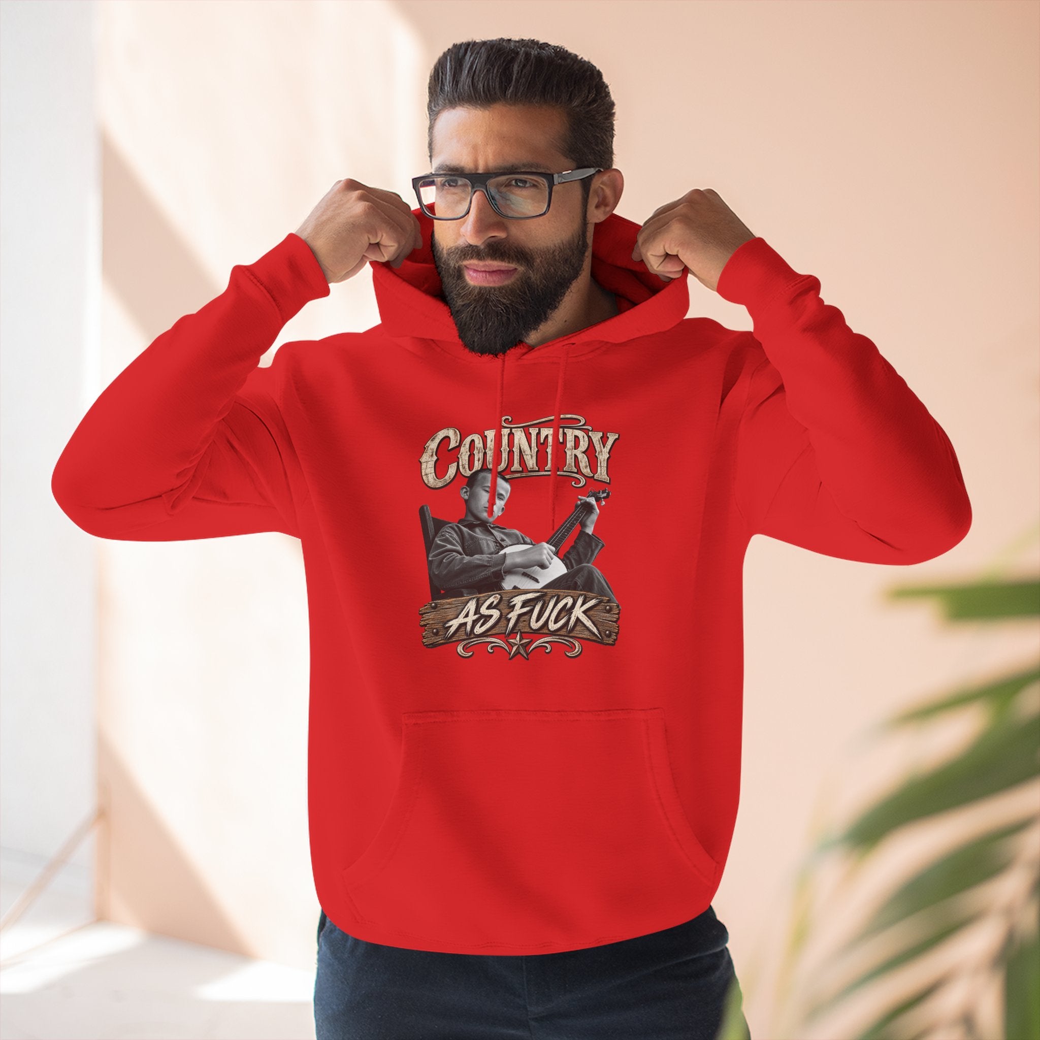 Bearded man in the Red Country As Fuck hoodie, banjo front print showing