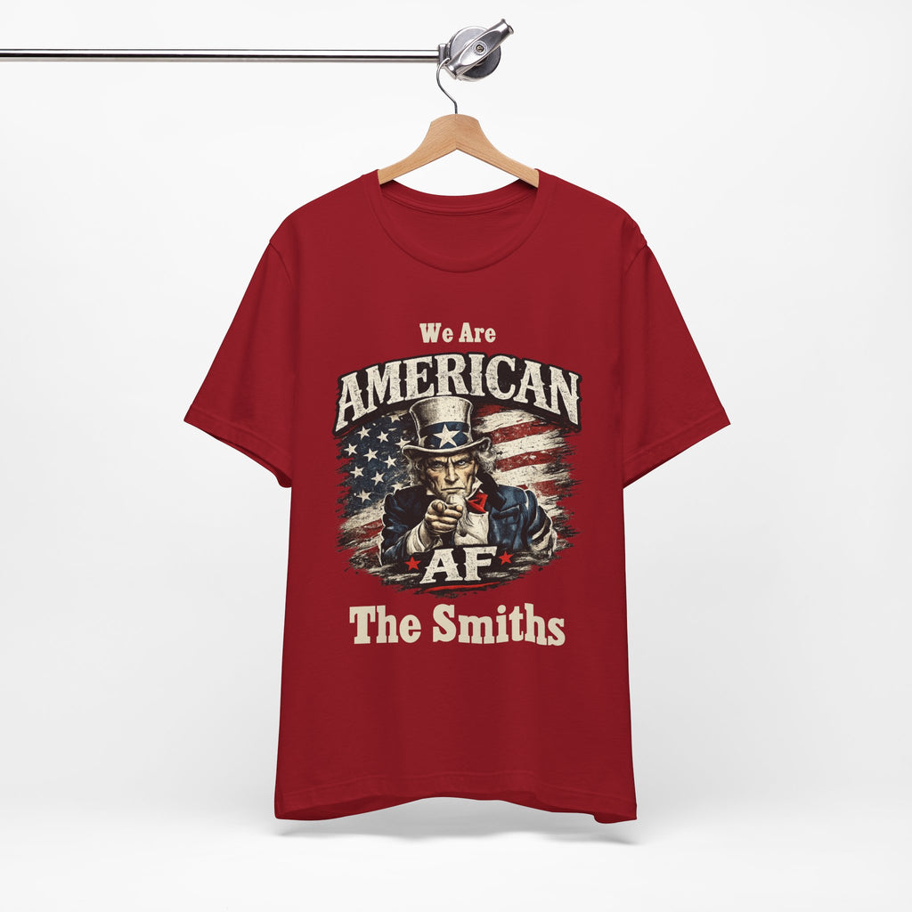 Orange t-shirt folded into a stack, top fold showing the Uncle Sam graphic and I'm American lettering.