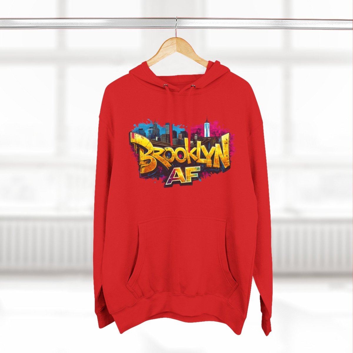 Red Brooklyn AF graffiti hoodie on a wooden hanger, street-art front print showing