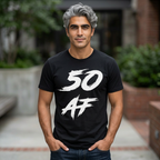 Grey-haired man outdoors on a brick walkway wearing the black 50 AF birthday tee with jeans